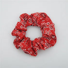 Red bandana patterned scrunchie on a white surface