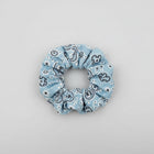 Blue floral scrunchie on a white surface